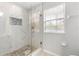 Walk-in shower with glass door and elegant white marble-look tile and stone accents at 231 Ne 28Th Ave # 103, Ocala, FL 34470