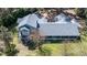 Aerial view of a home with a screened-in porch, set amidst a lush green lawn and surrounded by trees at 25 Lake Wood Cir, Ocala, FL 34482