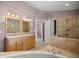 This bathroom is complete with a glass shower, a large tub, and a wooden double sink vanity at 25 Lake Wood Cir, Ocala, FL 34482