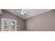 Bright bedroom features a ceiling fan, neutral walls, and access to outdoor space through glass doors at 25 Lake Wood Cir, Ocala, FL 34482
