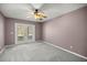 A cozy bedroom with a ceiling fan and door to the backyard at 25 Lake Wood Cir, Ocala, FL 34482
