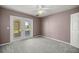 This bedroom is complete with neutral walls, carpeting, a ceiling fan, and exterior patio access at 25 Lake Wood Cir, Ocala, FL 34482