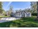 Home featuring an attached garage and a well-manicured lawn, providing convenient parking and curb appeal at 25 Lake Wood Cir, Ocala, FL 34482