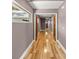 This naturally-lit hallway boasts hardwood floors, beautiful wood trim, and neutral colored walls at 25 Lake Wood Cir, Ocala, FL 34482