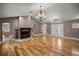 Open living area features hardwood floors, a fireplace, chandelier, and grand entryway at 25 Lake Wood Cir, Ocala, FL 34482