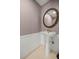 This powder room is complete with tile floors, decorative mirror, and pedestal sink at 25 Lake Wood Cir, Ocala, FL 34482