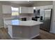 Bright kitchen featuring white cabinets, stainless steel appliances, and a quartz countertop island at 27 Laurel Ct, Ocala, FL 34472
