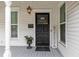 Charming front porch featuring a stylish black front door and classic white columns at 30 Se Wenona Ave, Ocala, FL 34471