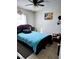 Inviting bedroom with a black-frame bed, a geometric rug, tiled flooring, and natural lighting from a side window at 310 Oak Track Dr, Ocala, FL 34472