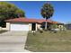 Charming single-story home with a red roof, a well-kept lawn, and a two-car garage at 310 Oak Track Dr, Ocala, FL 34472