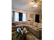 Comfortable living room featuring a large sectional sofa, a ceiling fan, and natural light from the curtained windows at 310 Oak Track Dr, Ocala, FL 34472
