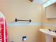 Neutral-toned bathroom featuring a pedestal sink, mirror, and towel bar at 3650 Ne 21St St, Ocala, FL 34470