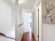 Upstairs hallway with wood floors, white walls, and doorways to the bedrooms at 3650 Ne 21St St, Ocala, FL 34470