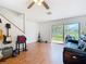 Spacious living room featuring wood-look floors, natural light, and sliding glass doors at 3650 Ne 21St St, Ocala, FL 34470