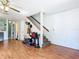 Open-concept living room with hardwood floors, ceiling fan, and stairs to the upper level at 3650 Ne 21St St, Ocala, FL 34470