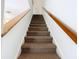 Carpeted stairs with wooden handrails lead to the upper level at 3650 Ne 21St St, Ocala, FL 34470