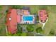 Aerial view of the property featuring a pool, lush landscaping, and multiple buildings with red tile roofs at 411 Sw 38Th St, Ocala, FL 34471