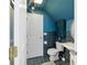 Compact bathroom featuring a toilet, sink, and built in storage with blue walls and tile at 411 Sw 38Th St, Ocala, FL 34471
