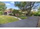 Long driveway leading to a home with a two-car garage, carport and beautifully landscaped yard at 411 Sw 38Th St, Ocala, FL 34471