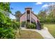 Two-story home featuring a private balcony, lush greenery, and a well-maintained lawn at 411 Sw 38Th St, Ocala, FL 34471