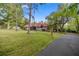 Charming home featuring a red-tiled roof, well-manicured lawn, and mature trees creating a serene setting at 411 Sw 38Th St, Ocala, FL 34471