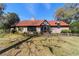 Charming home featuring a stone facade, red tile roof, and mature landscaping at 411 Sw 38Th St, Ocala, FL 34471