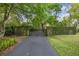Metal driveway gate and stone walls covered in greenery, providing a secure and private entrance at 411 Sw 38Th St, Ocala, FL 34471