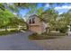 Spacious two-car garage with a paved driveway, enhanced by mature trees and lush landscaping at 411 Sw 38Th St, Ocala, FL 34471