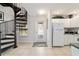 Hallway with spiral staircase and access to the kitchen featuring white cabinets at 411 Sw 38Th St, Ocala, FL 34471