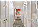 Hallway with built-in closets, vanity, vibrant red wall and bold patterned carpeting at 411 Sw 38Th St, Ocala, FL 34471