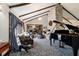 Elegant living room featuring vaulted ceilings, a stone fireplace, and a grand piano, perfect for entertaining at 411 Sw 38Th St, Ocala, FL 34471