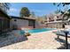 Exterior view of in-ground pool surrounded by brick pavers, lush greenery, and the back of the house at 411 Sw 38Th St, Ocala, FL 34471