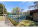 Outdoor tennis court surrounded by a fence and greenery on a sunny day, great for recreation at 411 Sw 38Th St, Ocala, FL 34471