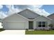 Charming single-story home with a two-car garage, manicured lawn, and light green front door at 4770 Sw 88Th Ln, Ocala, FL 34476