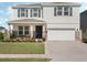 Charming two-story home featuring a manicured lawn, stone accents, and a welcoming front porch at 5021 Sw 88Th St, Ocala, FL 34476