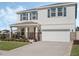 Charming two-story home featuring a manicured lawn, stone accents, and a two car garage at 5021 Sw 88Th St, Ocala, FL 34476
