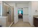 A bright bathroom with a glass-enclosed shower, connecting to a bedroom for easy access, and featuring neutral tiling at 5021 Sw 88Th St, Ocala, FL 34476