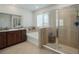 A well-lit main bathroom featuring a soaking tub, glass-enclosed shower, and neutral tiling for a clean, modern aesthetic at 5021 Sw 88Th St, Ocala, FL 34476