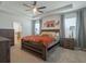 A spacious main bedroom with a tray ceiling, fan, and ensuite bath, providing a comfortable and luxurious retreat at 5021 Sw 88Th St, Ocala, FL 34476