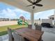 Covered patio with outdoor dining set overlooking the backyard with playset and seating at 5021 Sw 88Th St, Ocala, FL 34476