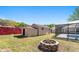 Backyard with shed, fire pit, swimming pool, and secure fencing, offering outdoor activities and relaxation at 5041 Ne 4Th St, Ocala, FL 34470