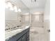 This newly renovated bathroom features a granite countertop, a vanity, a bathtub, updated fixtures, and gray tile at 5041 Ne 4Th St, Ocala, FL 34470