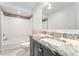 A charming bathroom features a granite vanity, and a shower tub with modern fixtures at 5041 Ne 4Th St, Ocala, FL 34470