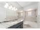 This newly renovated bathroom features a granite countertop, a vanity, a bathtub, updated fixtures, and gray tile at 5041 Ne 4Th St, Ocala, FL 34470