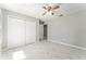 This bedroom features a ceiling fan, marble tile floors, closet, and a door leading to another room at 5041 Ne 4Th St, Ocala, FL 34470