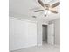 This bedroom features a ceiling fan, marble tile floors, a closet, and a door leading to another room at 5041 Ne 4Th St, Ocala, FL 34470