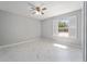 This bedroom features a ceiling fan, marble tile floors, neutral paint, and a window with shutters to bring in natural light at 5041 Ne 4Th St, Ocala, FL 34470