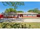 Charming ranch-style home with a brick facade, a well-manicured lawn, and beautiful landscaping at 5041 Ne 4Th St, Ocala, FL 34470