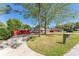 Exterior view of a single-story home with a long driveway, lawn, and mature trees at 5041 Ne 4Th St, Ocala, FL 34470