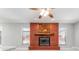 Bright living room with a ceiling fan and a charming brick fireplace with a rustic wooden mantel at 5041 Ne 4Th St, Ocala, FL 34470